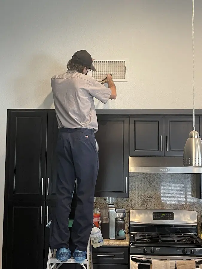 Technician inspecting an air vent during HVAC service in Union